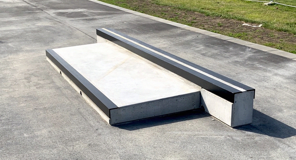 En betoncurb i to niveauer med store metalkanter på