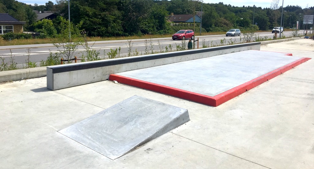 Her ses en meget lang curb med metalkant over en lille fortovsstørrelse platform med rødmalet fortovskant