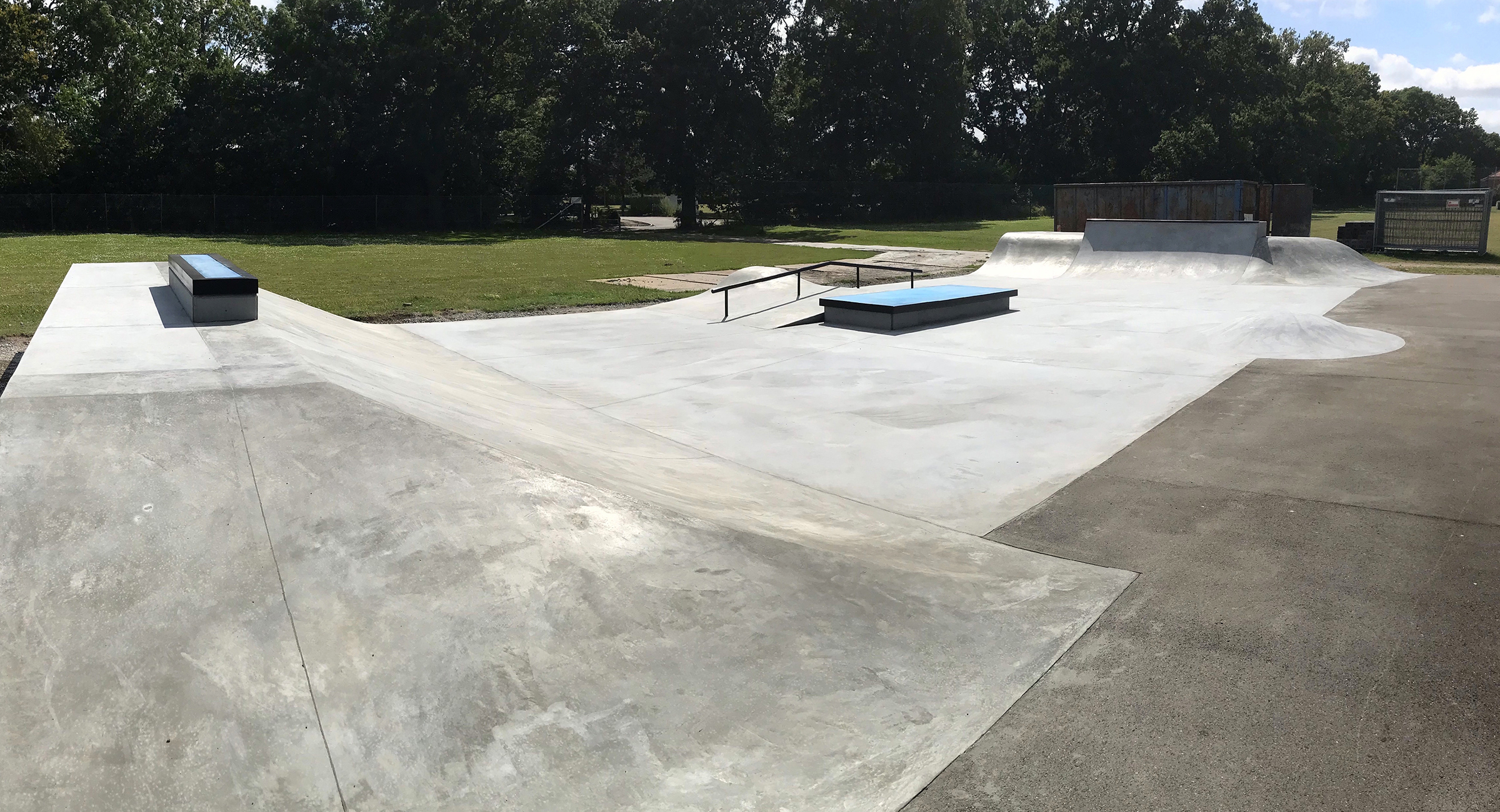 Her ses et hip i beton i forgrunden og en mindre skatepark bagved