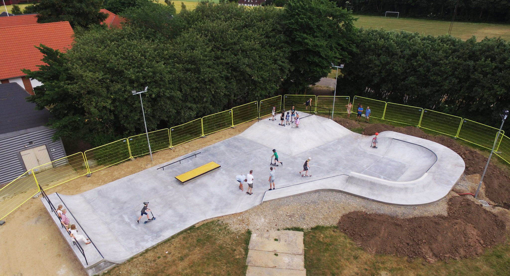 Et luftfoto af en beton skatepark fyldt med brugere