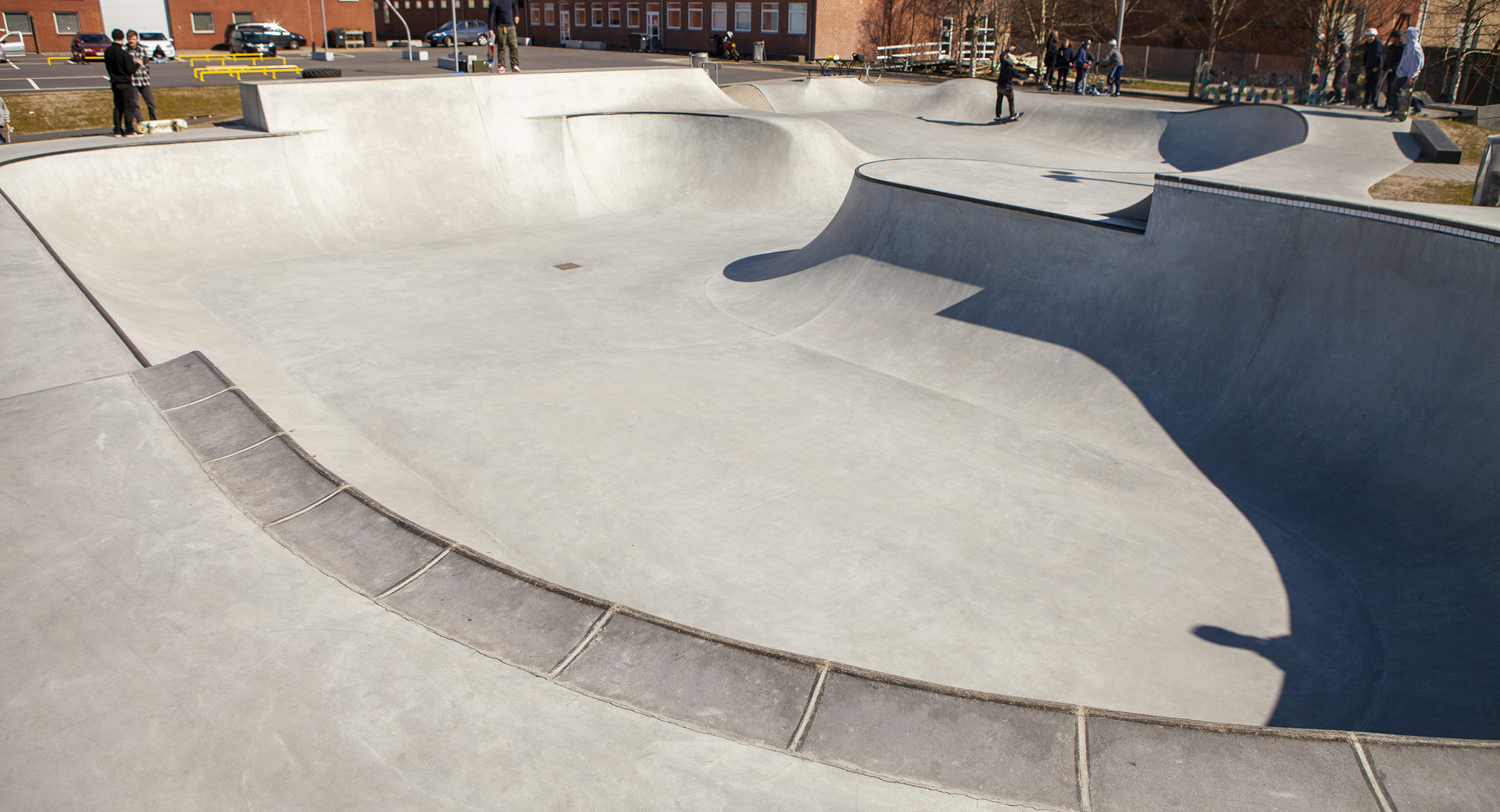 En skateboard bowl i beton med pool coping tæt på kameraet og metalcoping på de fjernere dele