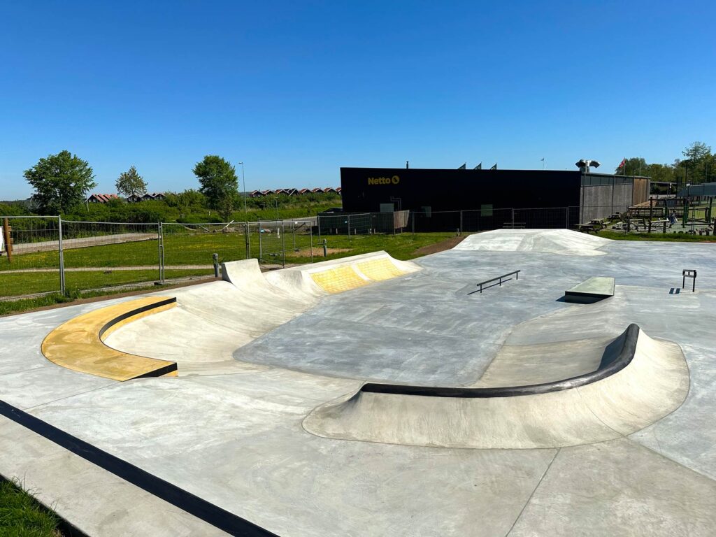 Overblik over Juelsminde Naturparks nye beton skatepark ved Ringvejen. Her er både små og store quarterpipes