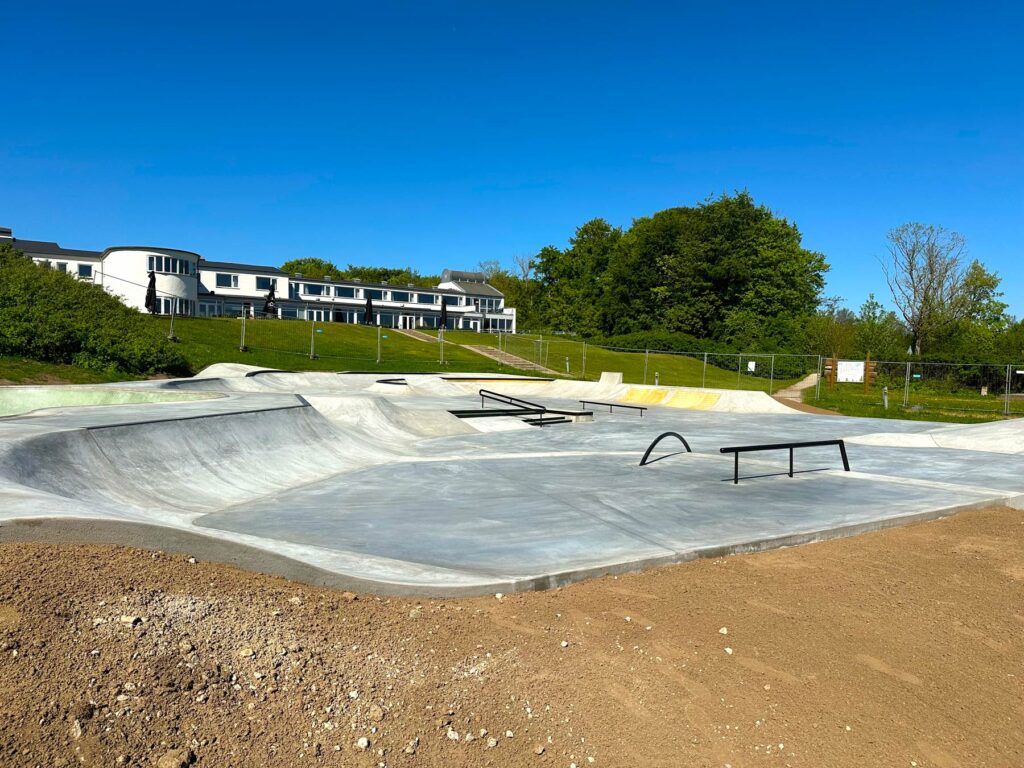 Overblik over Juelsminde Skatepark med forskellige rails og transitioner i mange størrelser