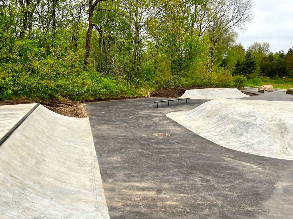 En lille beton skatepark mellem træerne i Kølvrå, Karup Jylland. Her er både et sort rail, quarterpipes og et stort hip