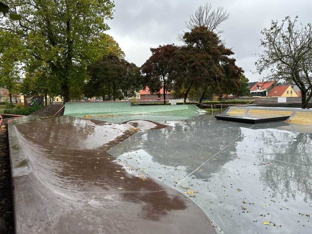 Billede af beton skatepark i Karolinelunden Aalborg hvor der er quarterpipes og hips i flere størrelser