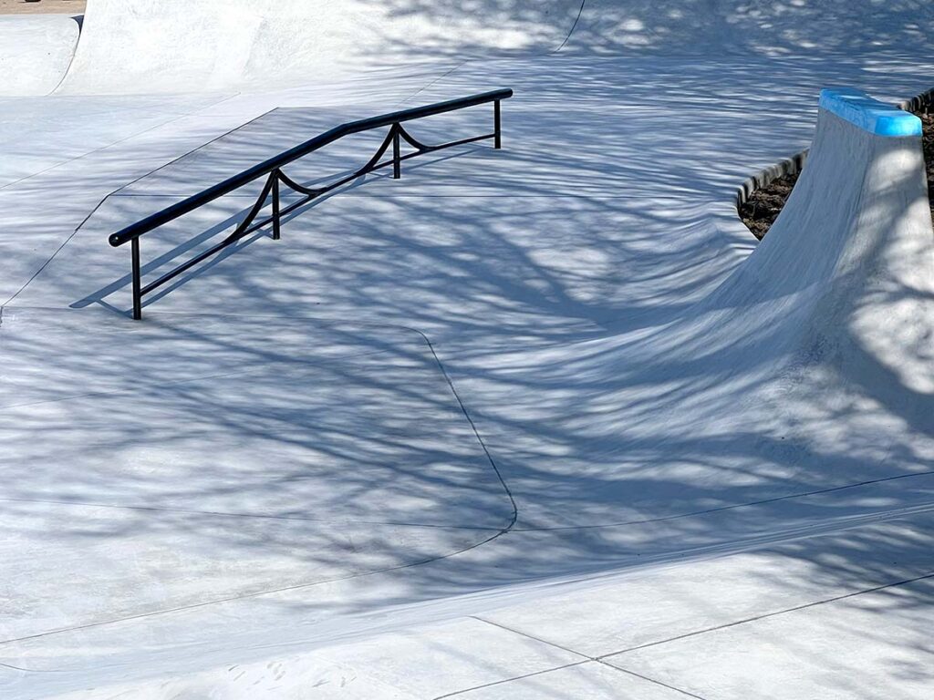 Sort smedet rail går hen og ned fra et lille plateau i Middelfart Skatepark