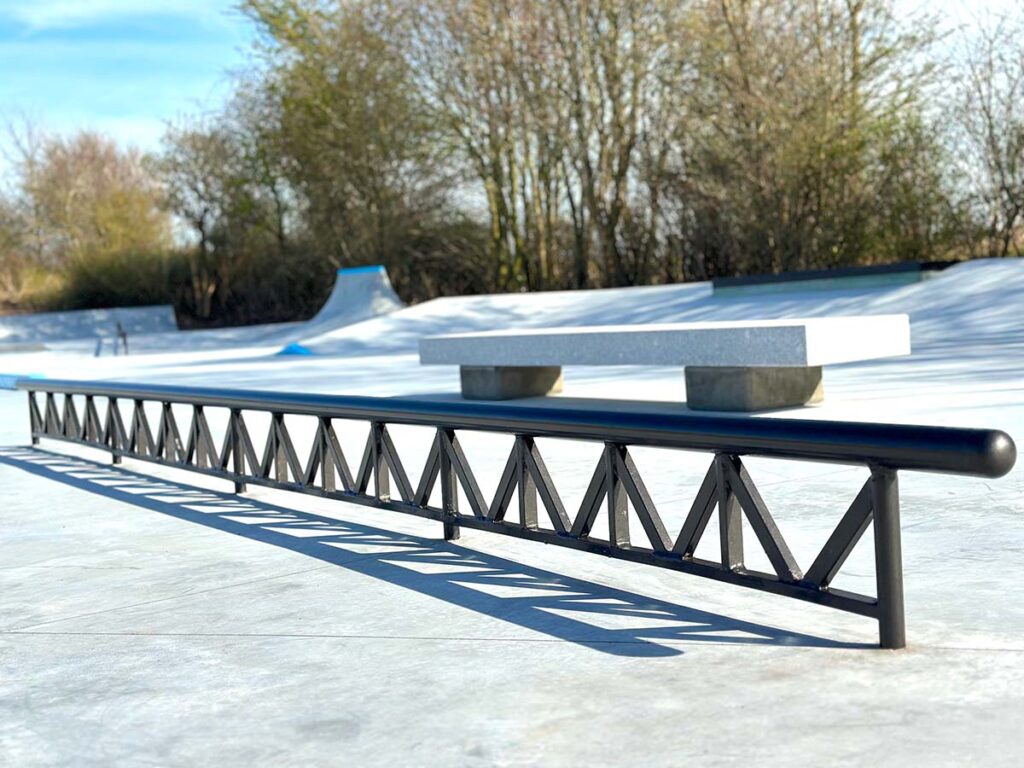 Nærbillede af sort smedet rail i Middelfart Skatepark. Railet er forstærket af en masse skrå elementer